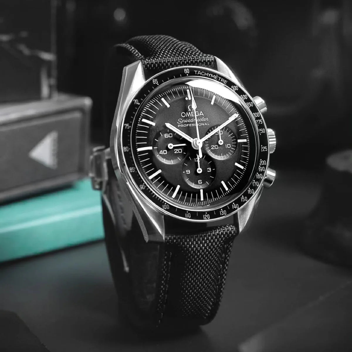 Black and silver watch with detailed face on a dark surface