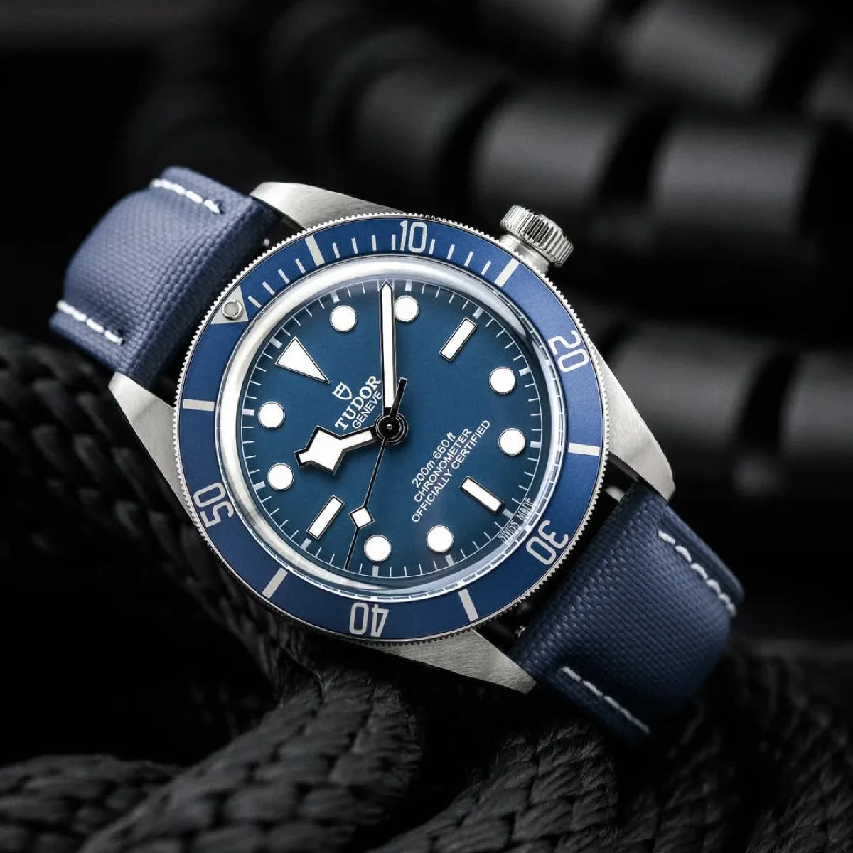Blue watch with silver accents on a textured black background