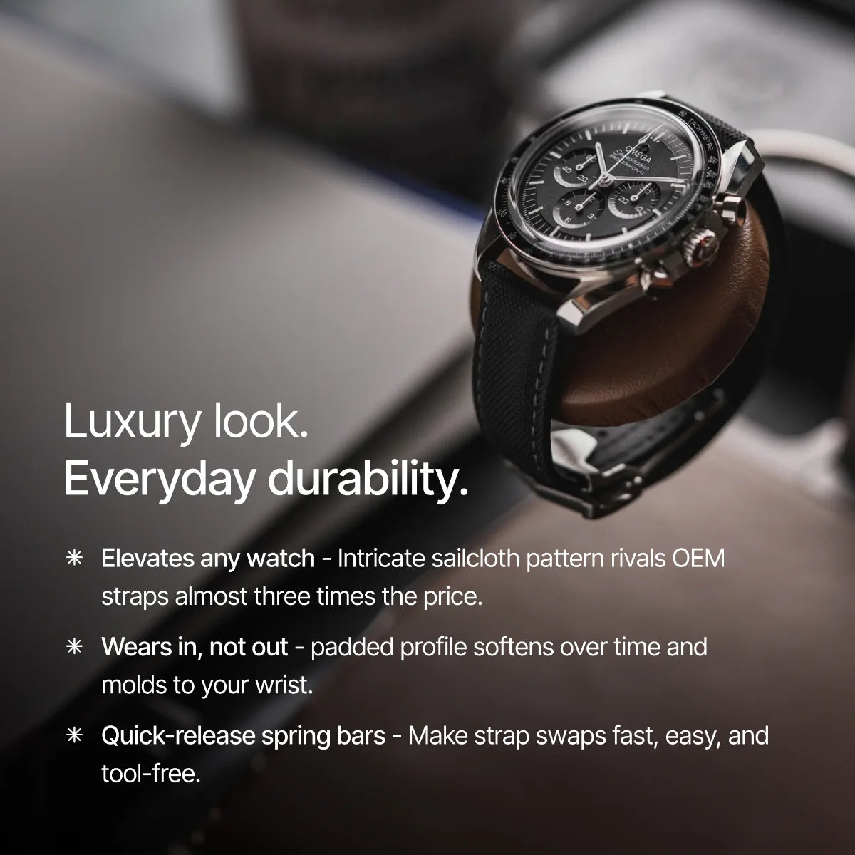 Luxury watch with black strap and detailed face on a blurred background