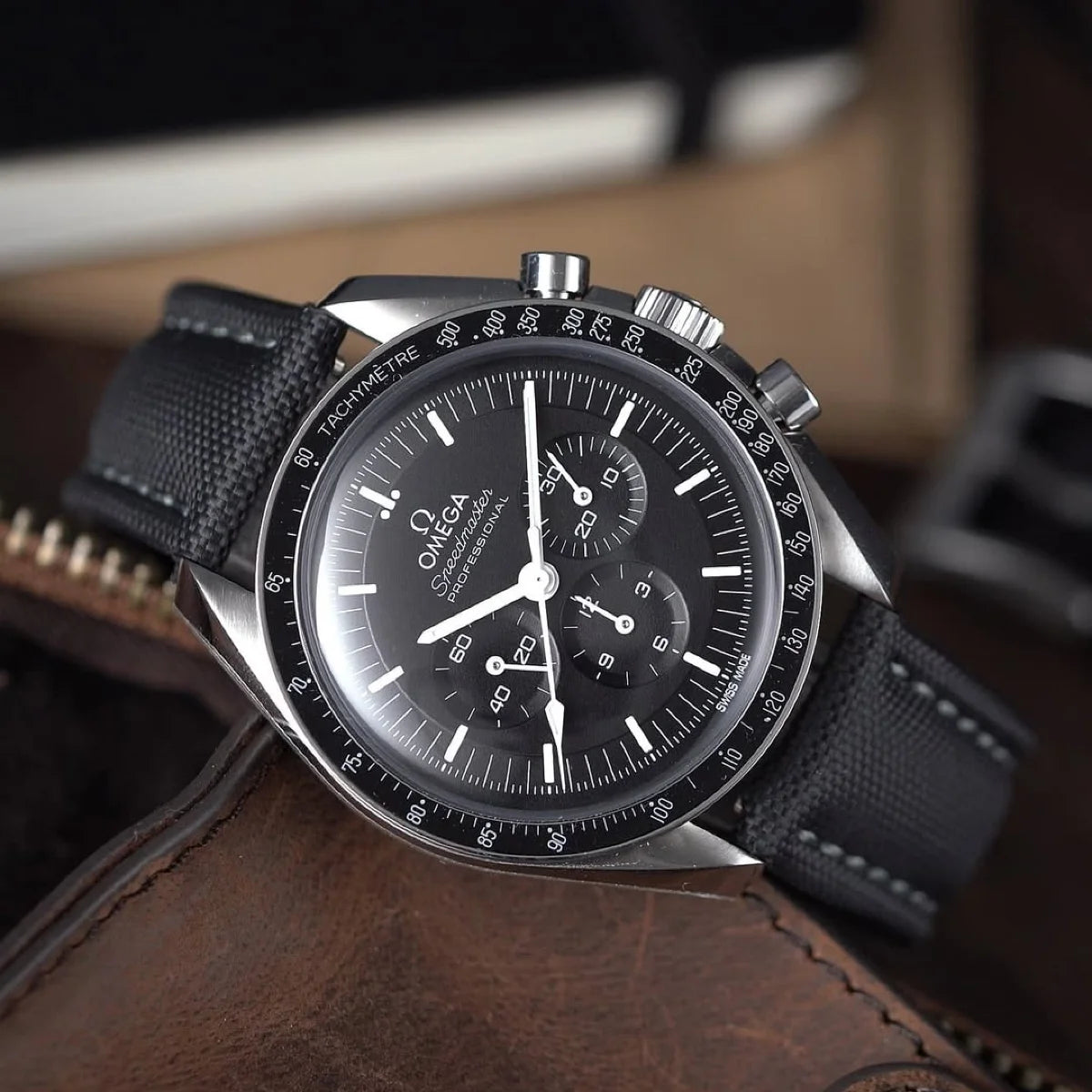 Omega watch with black strap on a brown surface