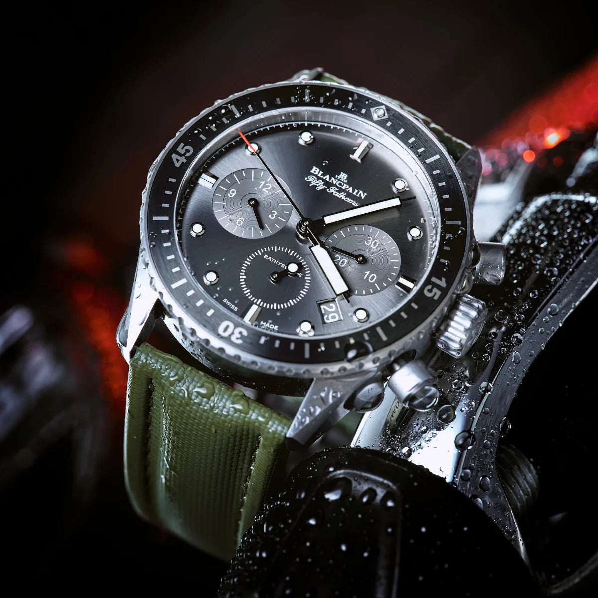 Luxury watch with a green strap on a dark background