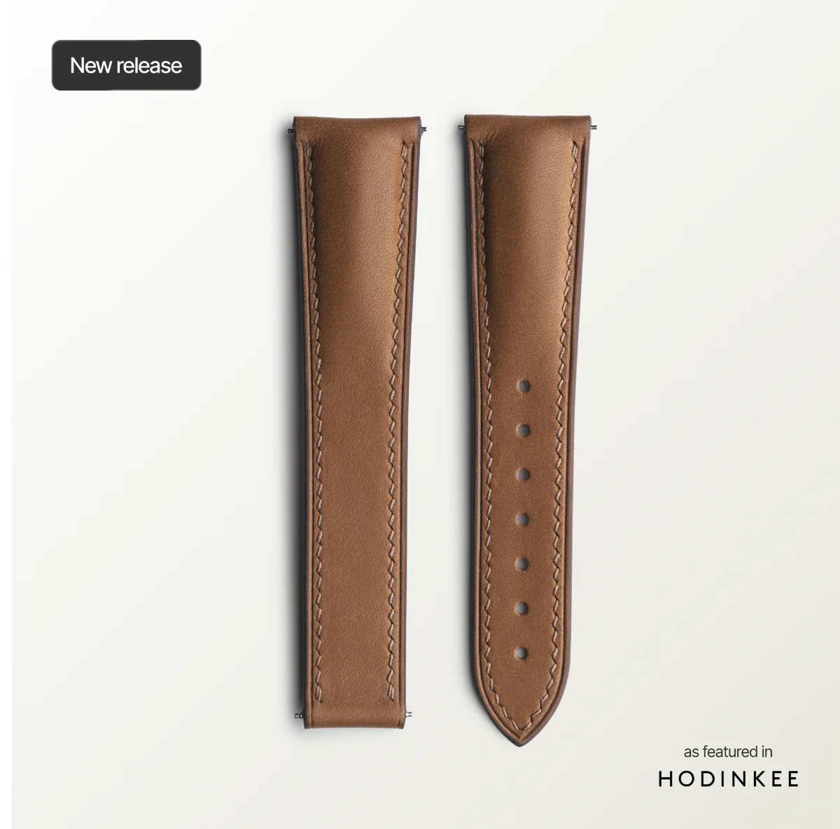 Brown leather watch strap on a light gray background with 'Hodinkee' branding.
