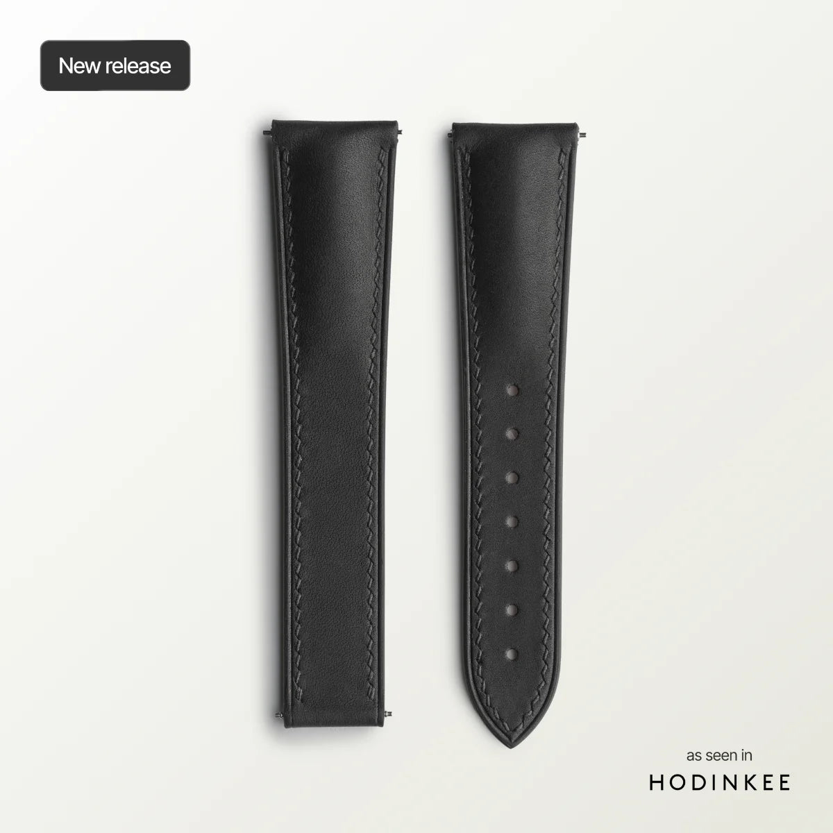 Black leather watch strap on a light gray background with 'HODINKEE' branding.