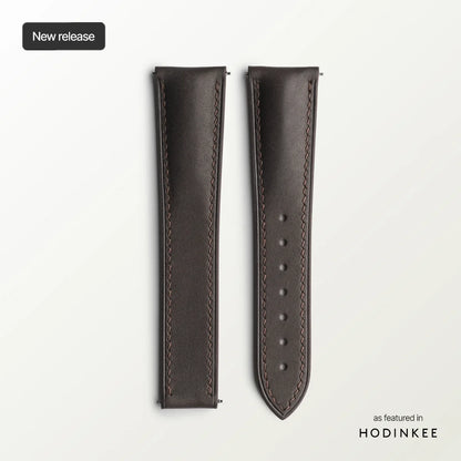 Brown leather watch strap with stitching details on a light gray background, featuring 'Hodinkee'.