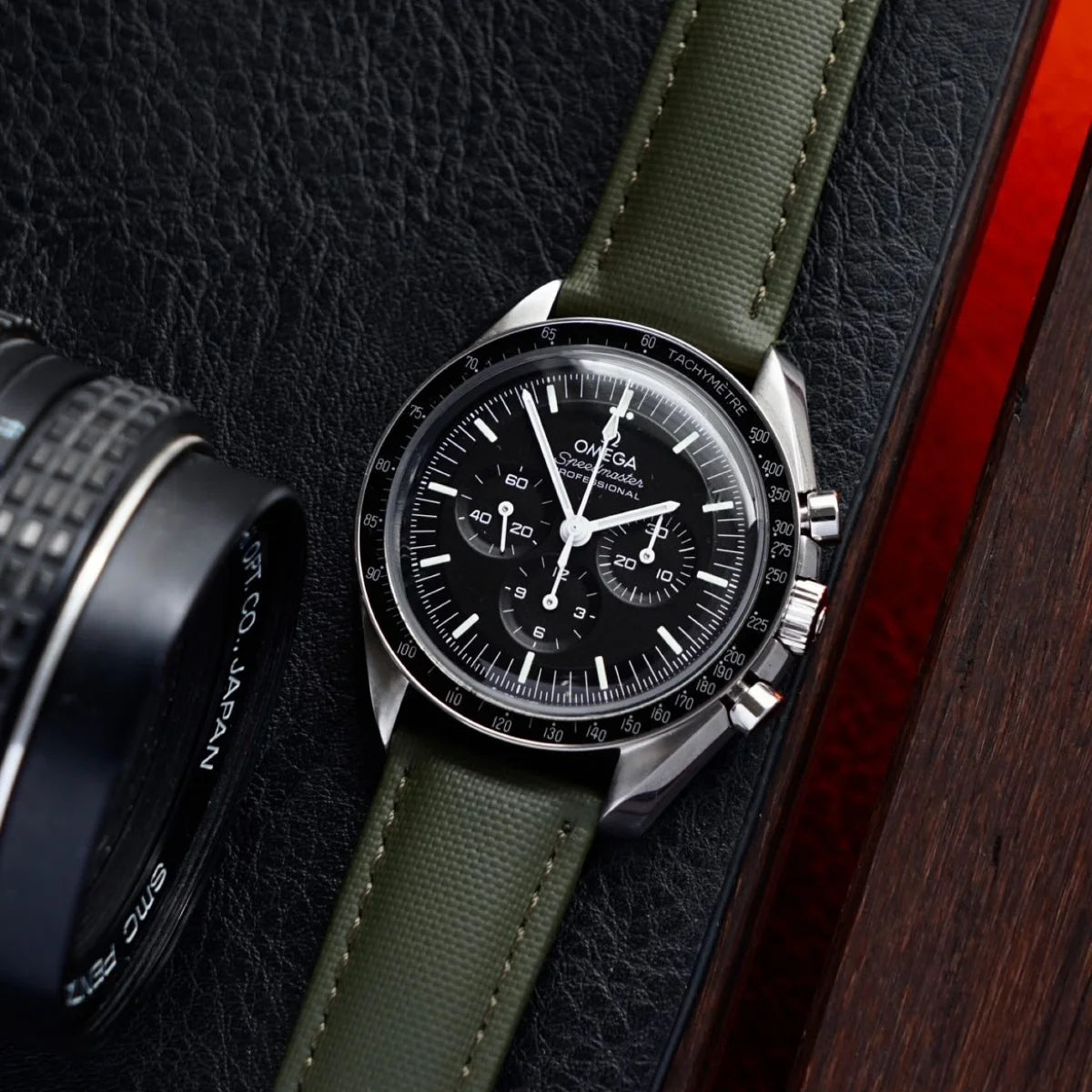 Omega watch with green strap on a textured surface