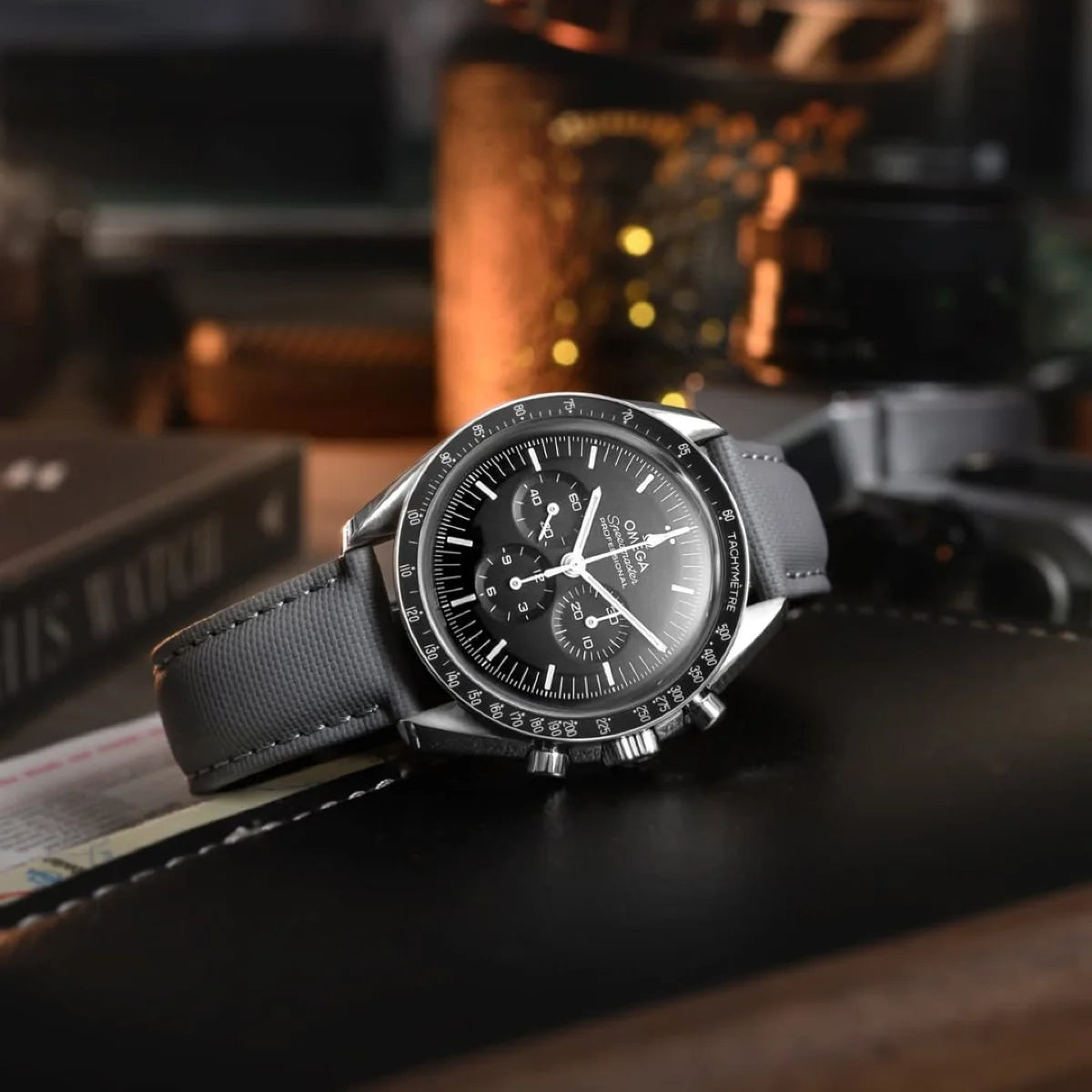 Black wristwatch with detailed face on a dark surface, blurred background