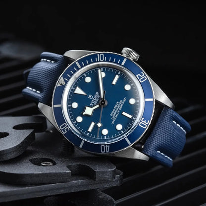 Blue watch with a detailed face on a dark background