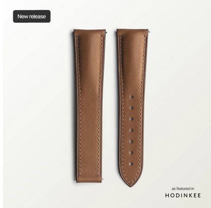 Brown leather watch strap on a light gray background with 'Hodinkee' branding.