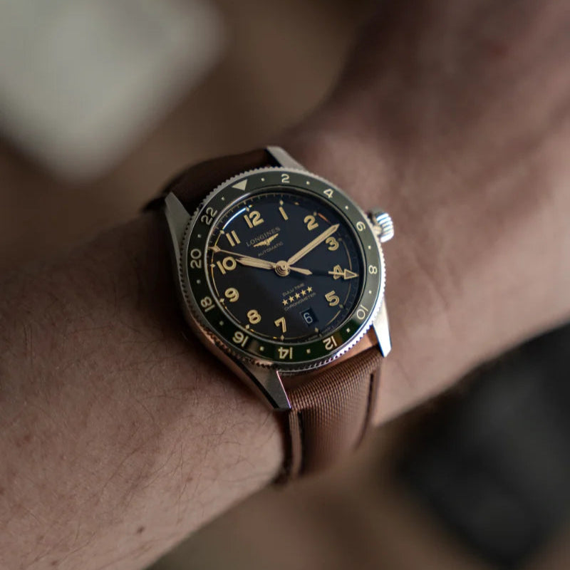 Close-up of a wrist wearing a watch with a brown strap and dark face.